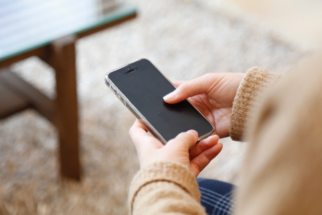 東京の質屋にアイフォン（iPhone）を質入れするなら「かづさや質店」 - iPhoneを手に持つ様子